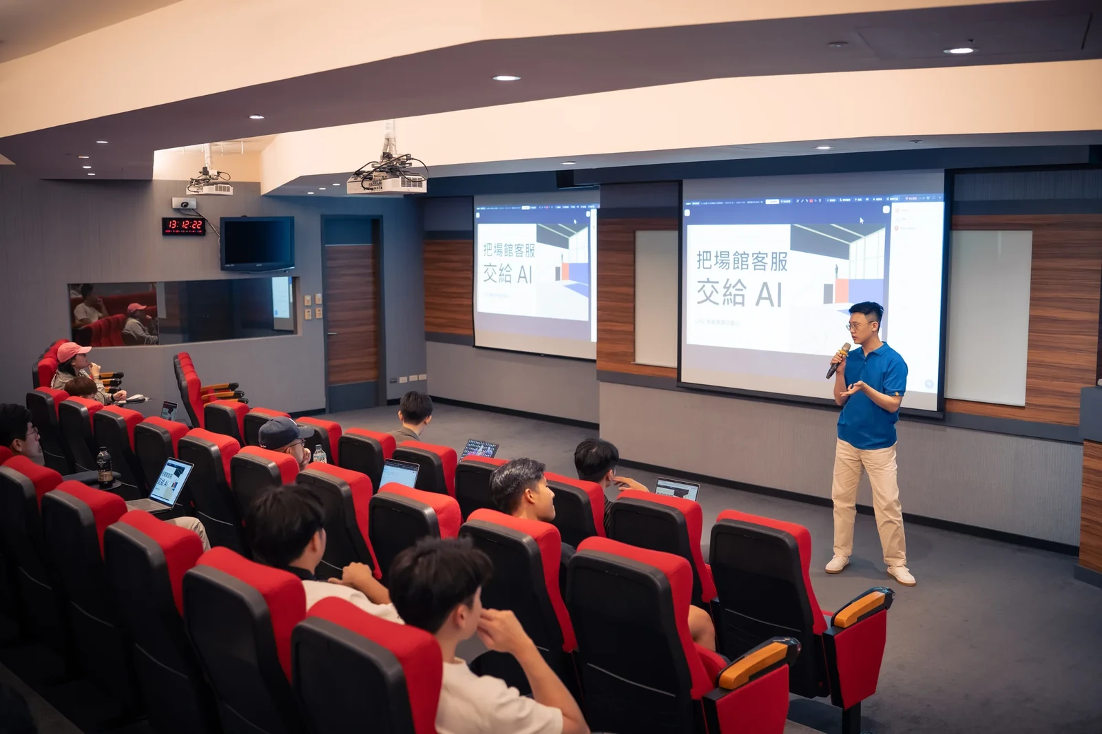 施文凱在講台前對照投影片,向學員講解 AI 客服流程