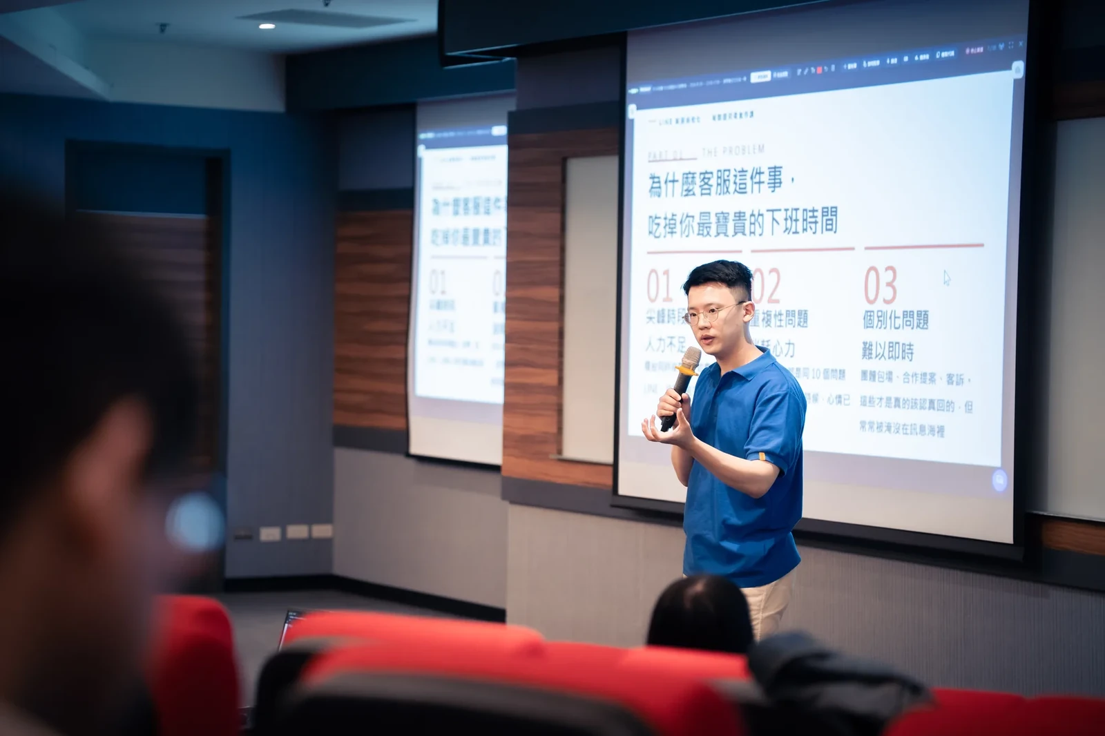 施文凱手持麥克風,對照投影片說明客服工作的常見問題